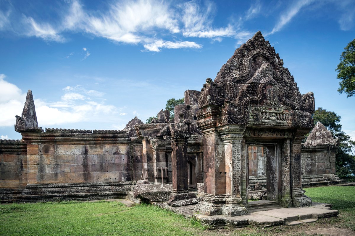 A section of the Preah Vihear Temple complex in Cambodia, set against blue skies with green grass in the foreground