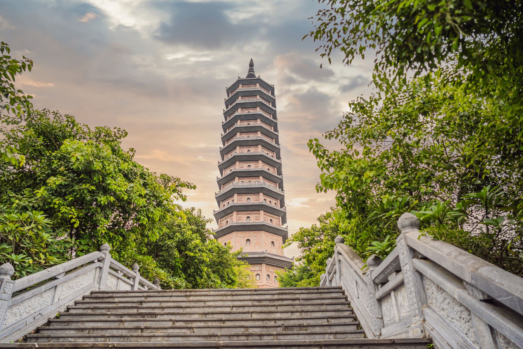 Temple tower of Bái Đính Pagoda in Ninh Bình, surrounded by lush greenery and intricate carvings