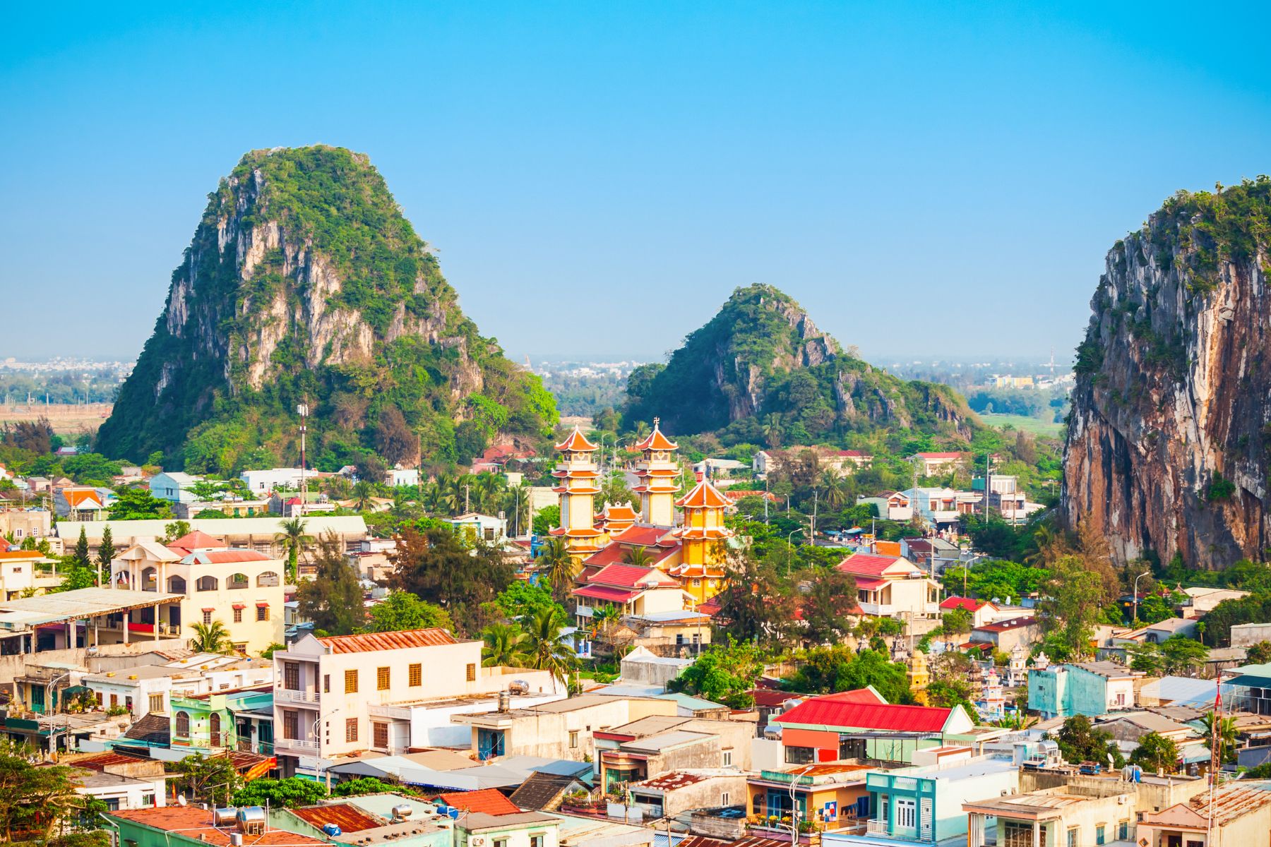 Landscape view of Marble Mountains with three peaks, local township buildings, and traditional Vietnamese architecture in Da Nang