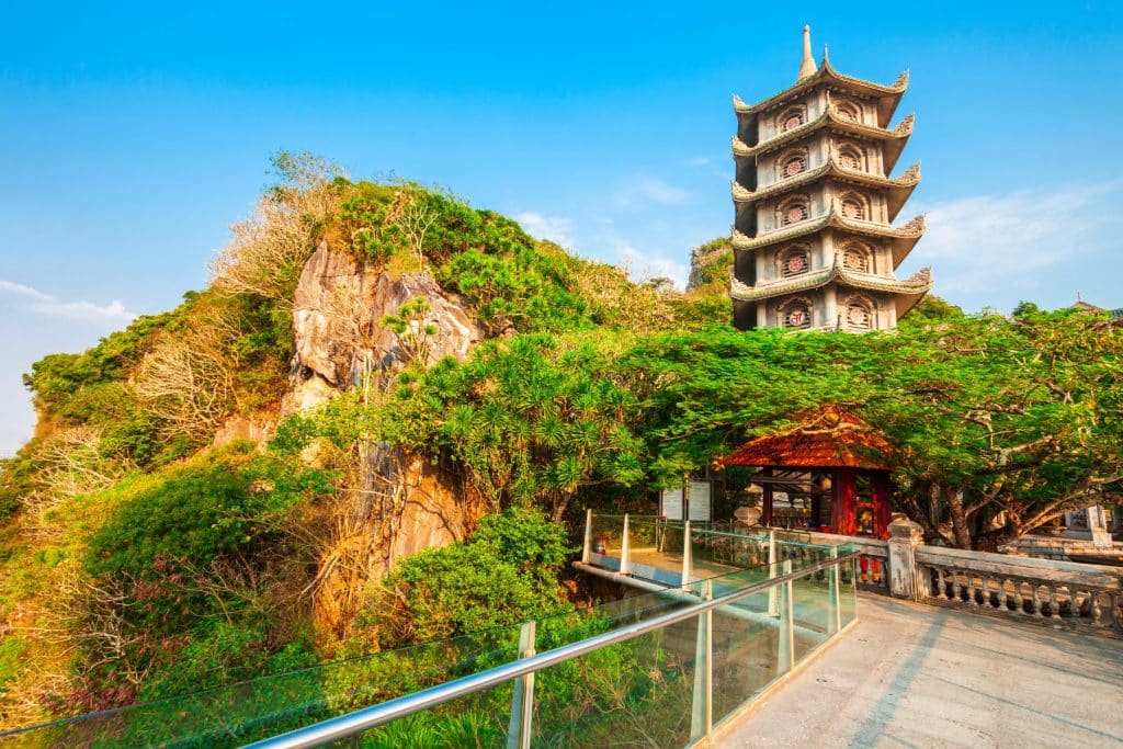 Scenic shot of Da Nang's Marble Mountains with lush greenery and cultural landmarks, featured in the Dawn to Dusk Da Nang Culture and Natural History Tour