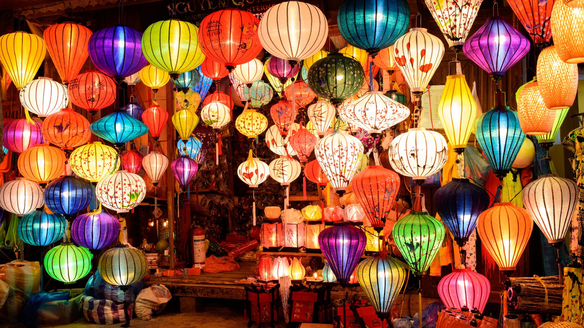 A vibrant street in Hoi An illuminated by colorful silk lanterns, creating a warm and enchanting atmosphere in the historic town.