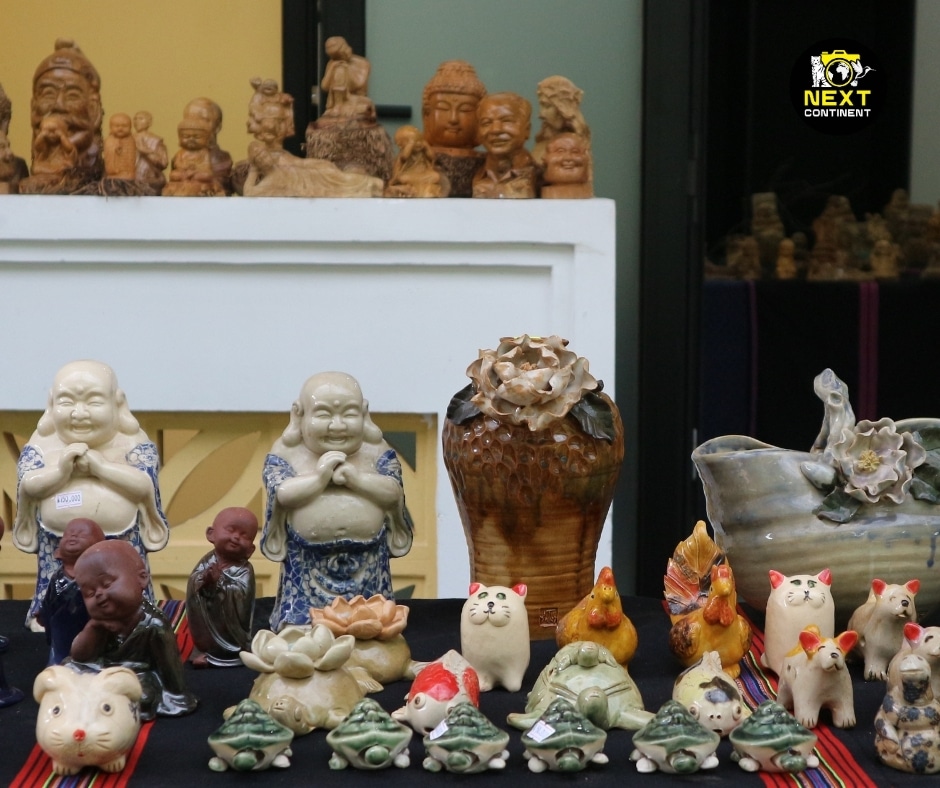 A vibrant display of handcrafted ceramics at Thanh Hà Pottery Village, featuring Buddhist statues, miniature animal figurines, and intricately designed vases. The collection showcases the rich artistic heritage and craftsmanship of Vietnamese pottery, with a mix of traditional and playful designs.