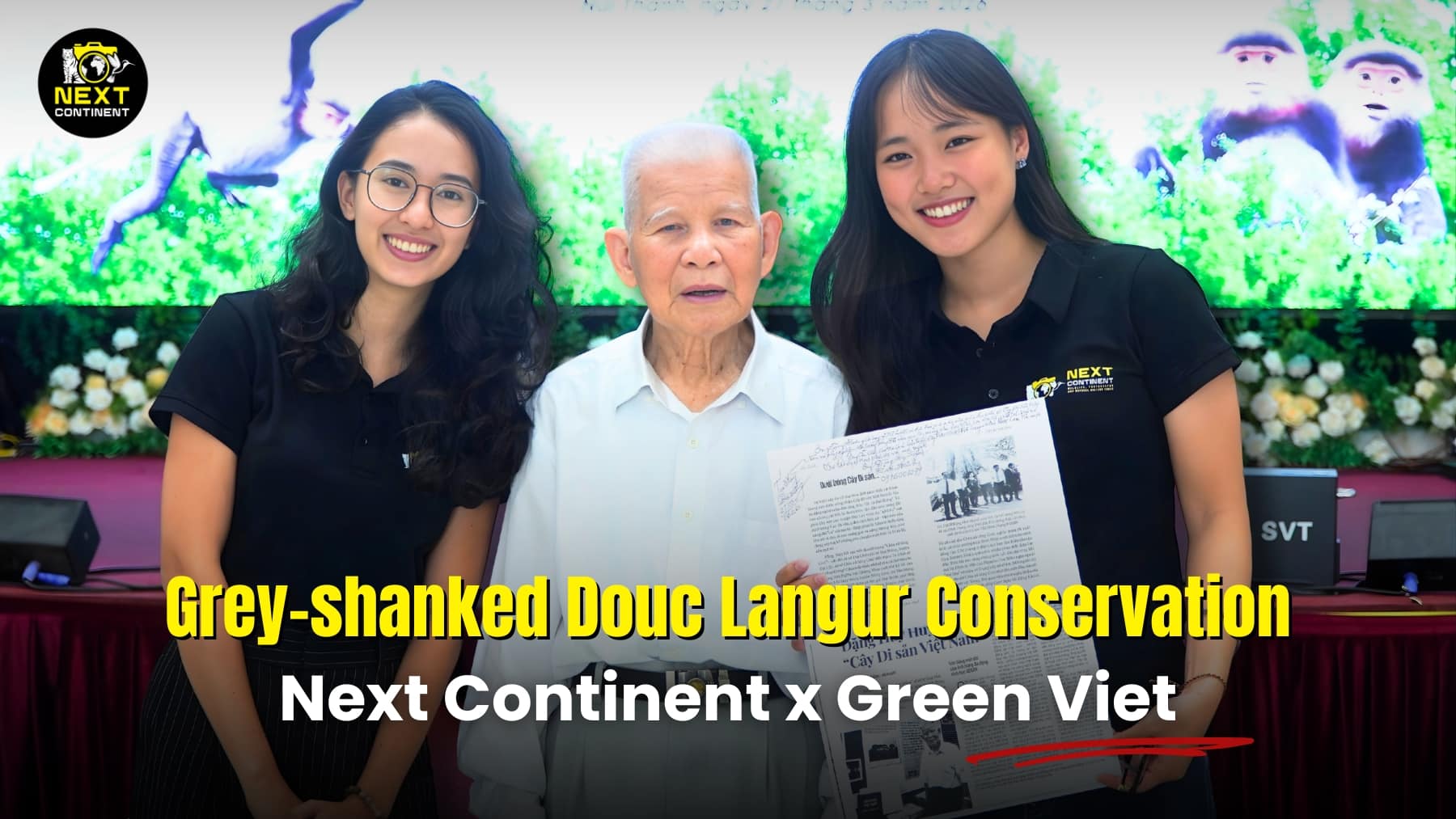 Three people holding a document at a conservation conference on grey-shanked douc langurs in Vietnam