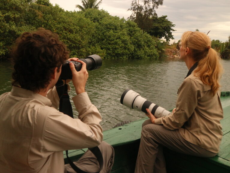 Birders photographing wildlife from a cruise during the Wild Hoi An 1-Day Birding Tour